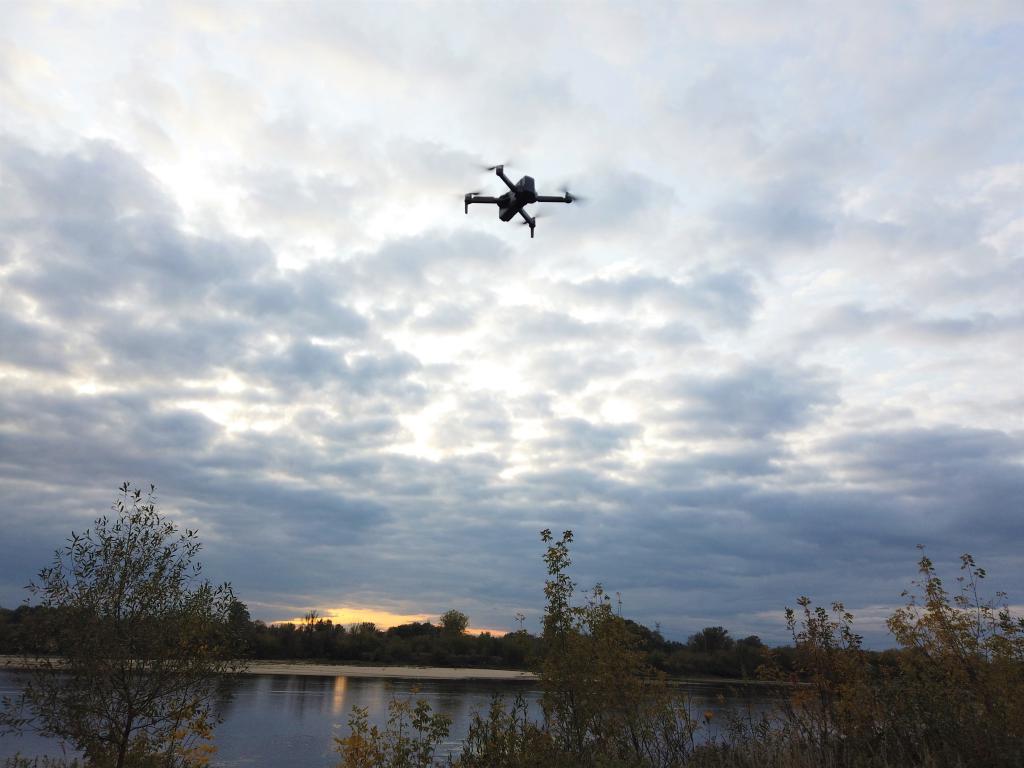 Recenzja drona SJRC F11 PRO - dron odlatuje w kierunku zachodu słońca