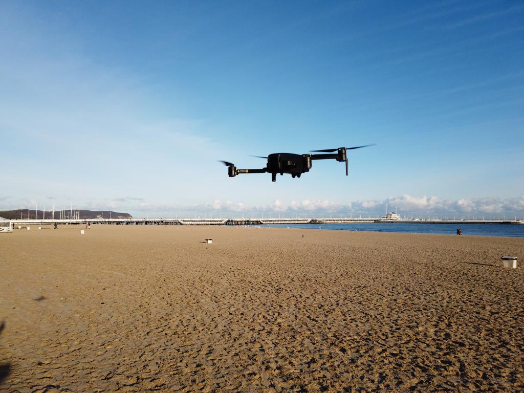 Hubsan Zino PRO - recenzja drona z kamerą 4K i zasięgiem aż 4 km - dron nad plażą w locie